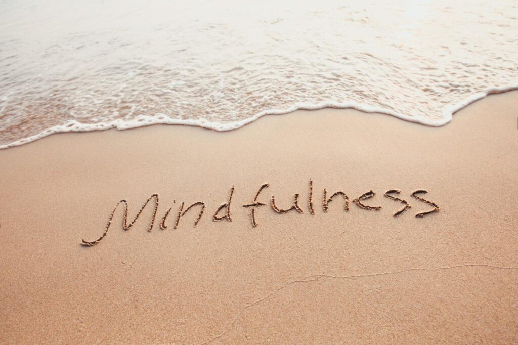 mindfulness geschreven in het zand