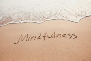 mindfulness geschreven in het zand